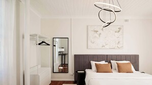 A modern bedroom with a large bed, a wardrobe, a mirror, and a ceiling light fixture. - The Brass Bear in Darlinghurst (Darlinghurst)