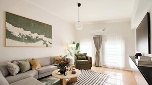A living room with a sofa, coffee table, and a painting on the wall. - The Brass Bear in Darlinghurst (Darlinghurst)