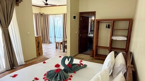 Ein Hotelzimmer mit einem großen Bett, einem Holzschrank und einem Deckenventilator.
