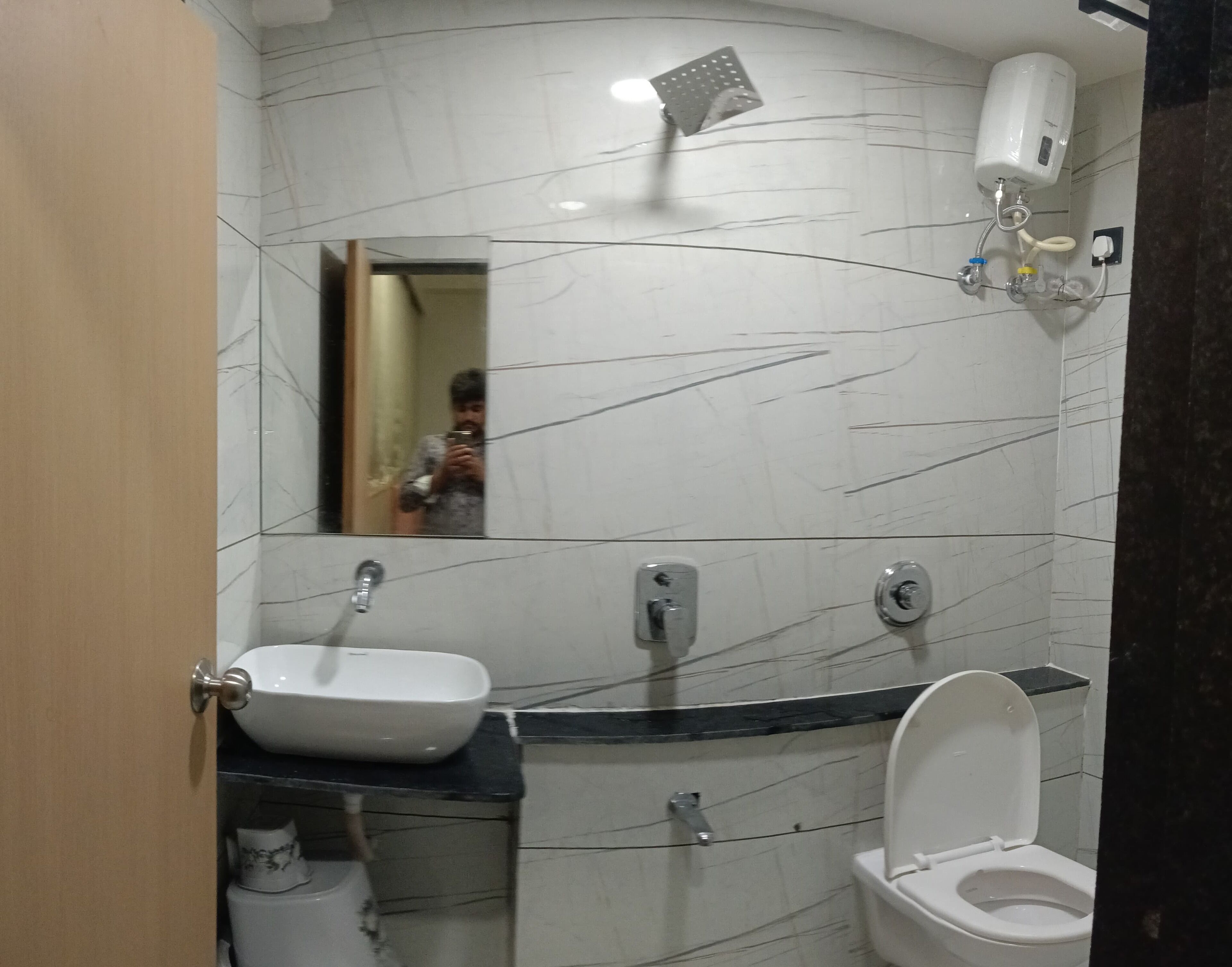A bathroom with a white sink, toilet, and a mirror.