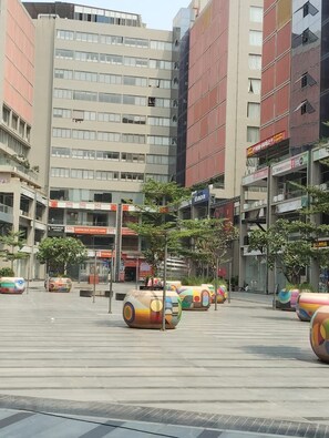 A modern urban plaza with colorful spherical sculptures, surrounded by multi-story buildings with commercial establishments. - Hotel Earth Orbit (Gandhinagar)