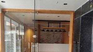 Un moderno vestíbulo de hotel con un separador de vidrio, un mostrador de recepción y un piso de mármol.