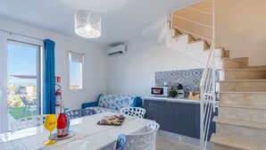 A modern kitchen with a microwave, a coffee maker, and a small plant on the counter. - Apartment 'I Due Mori Marzamemi' with Sea View, Wi-Fi and Air Conditioning (Marzamemi)