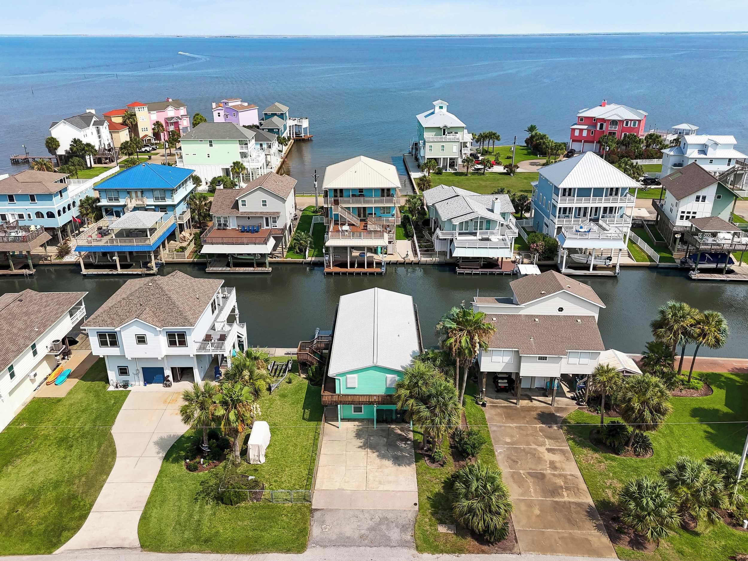 A residential area with houses along a waterway, featuring a mix of single and multi-story buildings, some with docks.