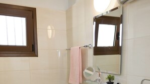 Un bagno con il water, un lavandino e uno specchio.