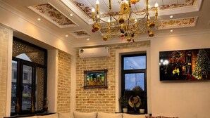 Una sala de estar moderna con un sofá modular, una mesa de centro y una araña.