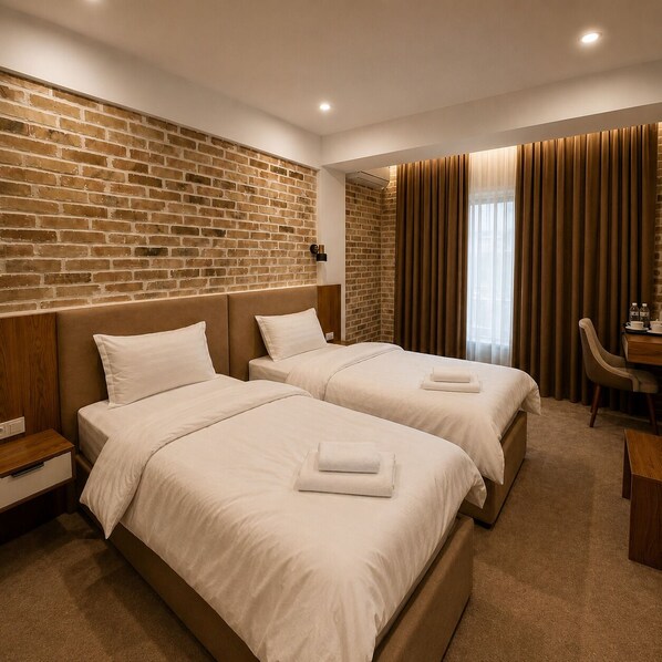 Une chambre d’hôtel avec deux lits, un mur en briques, un bureau en bois et une fenêtre avec des rideaux.