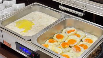 A buffet setup with a digital control panel, two food service stations, and a stainless steel container.