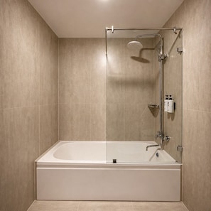 A modern bathroom with a glass-enclosed shower, a standalone bathtub, and a wall-mounted faucet.