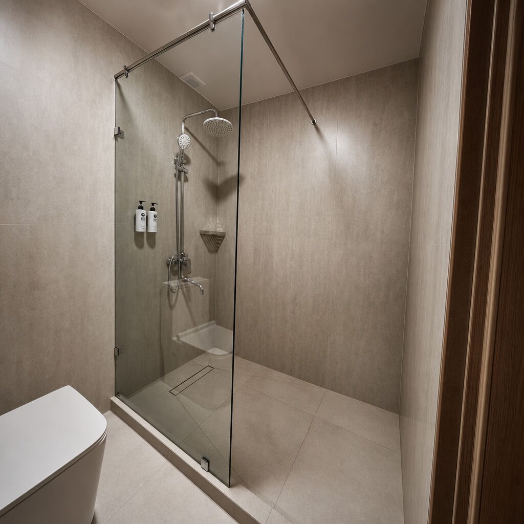 Un baño moderno con ducha de vidrio, inodoro y perchero para toallas.