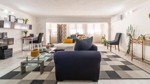 Un salon moderne avec un canapé, une table basse et un coin repas.