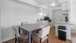A compact kitchen with white cabinets, a countertop, and a black trash bin. - Apt. In college Station TX Mins to major hospitals and A&M U (College Station)
