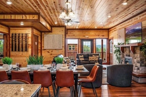 Un intérieur en bois comprenant un coin repas, un canapé et une cheminée.