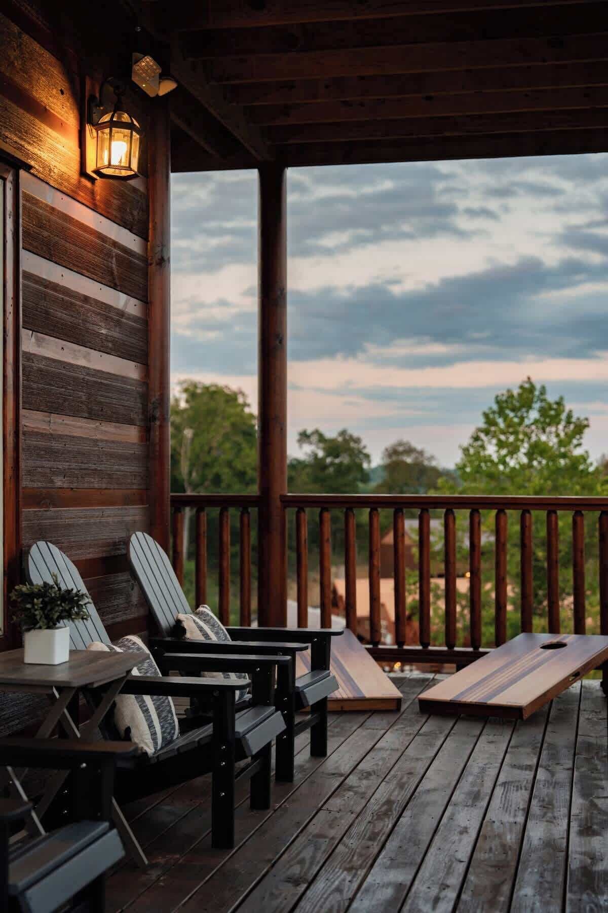 A wooden deck with Adirondack chairs and a table, overlooking a natural landscape.
