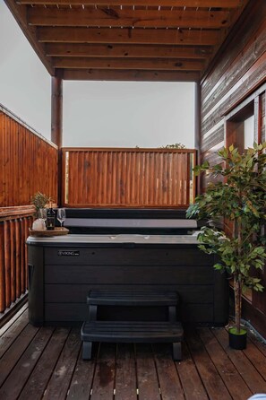 Un bain à remous avec une terrasse en bois et une clôture en bois.