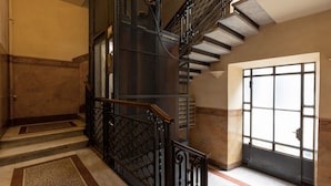 A staircase with a metal railing and a large window at the bottom. - Two-room Apartment Peace Arch - Mirable PM (Milano)