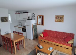 A compact living space with a kitchenette, a dining area, and a sofa. - Holiday Home 'Duplex Near Lake La Raviège' with Private Terrace and Private Garden (La Salvetat sur Agout)