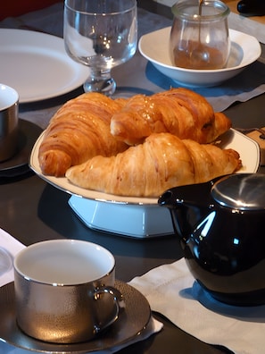 A table with croissants, a teapot, and a cup. - Bed and Breakfast 'Vert Ailleurs' with Shared Terrace, Shared Garden and Wi-Fi (Tavant)