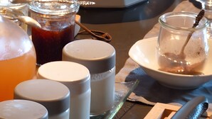 A breakfast setting with croissants, a coffee pot, and various containers likely for condiments and beverages. - Bed and Breakfast 'Vert Ailleurs' with Shared Terrace, Shared Garden and Wi-Fi (Tavant)