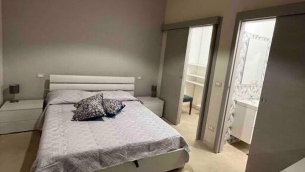 Ein Schlafzimmer mit Bett, Nachttischen und einem Kleiderschrank.