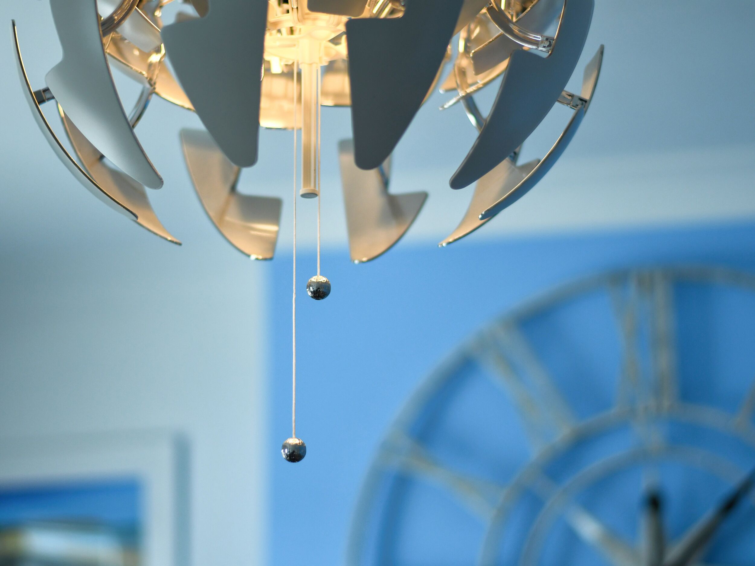 A chandelier with multiple arms and a spherical ornament hanging from the center.