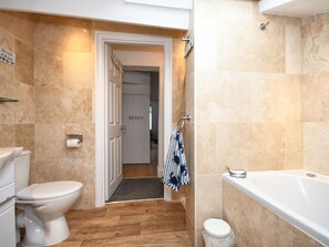 Ein Badezimmer mit Toilette, Badewanne und Duschbereich.