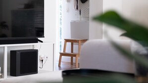 A modern living room with a large flat-screen TV, a wooden chair, and a small table. - Spacious vacation home in Tarcento - perfect for cyclists & hikers (Tarcento)