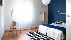 A bedroom with a bed, a chair, a wardrobe, a hanging light fixture, and a window with curtains. - Spacious vacation home in Tarcento - perfect for cyclists & hikers (Tarcento)