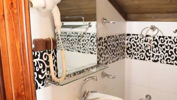 A bathroom with a white sink, a mirror, and a toilet.