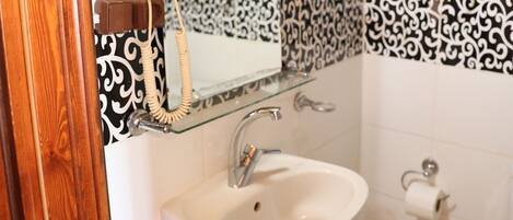 A bathroom with a white sink, a mirror, and a toilet.