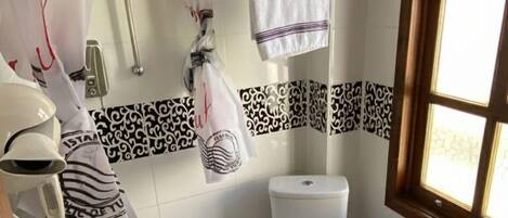 A compact bathroom with a toilet, sink, and shower area.