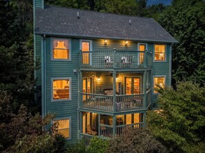 A two-story house with a balcony and multiple windows.
