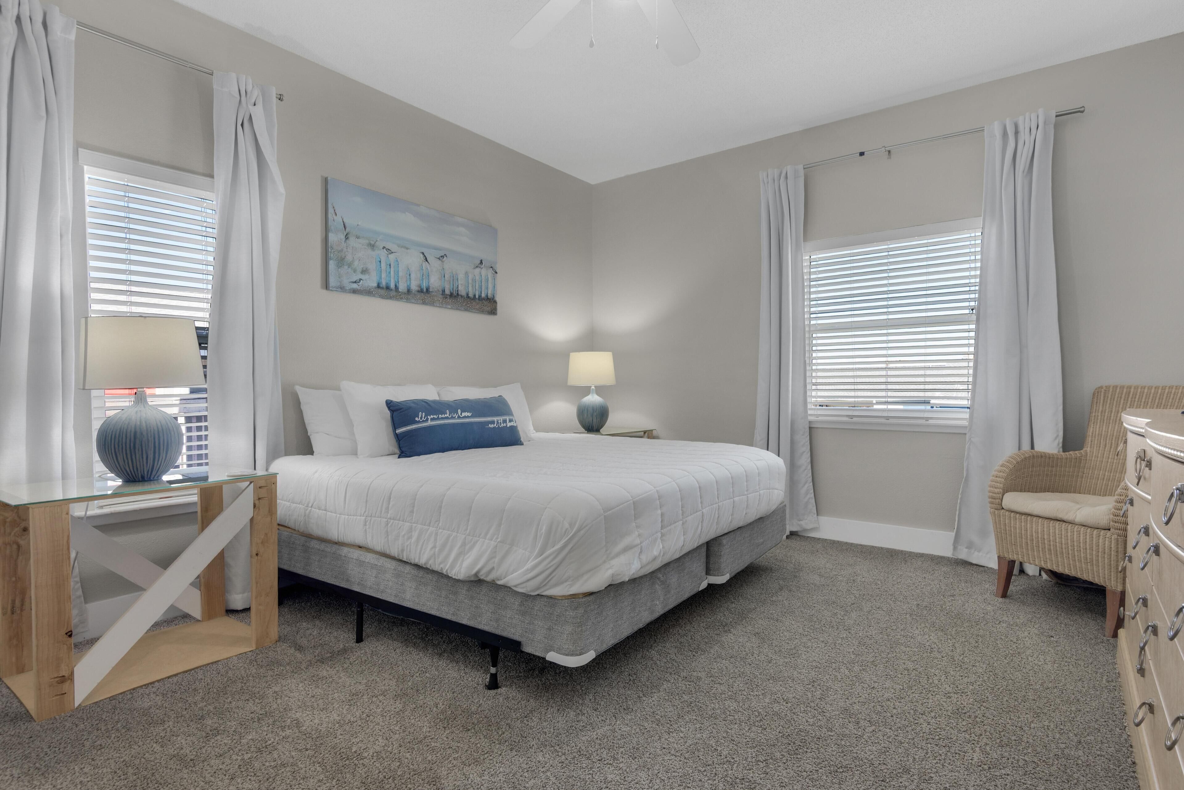 A bedroom with a bed, bedside tables, a lamp, a chair, and a dresser.