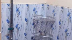 Un baño pequeño con inodoro, ducha y estantería.