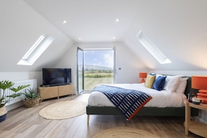 A bedroom with a bed, TV, and a view of the outdoors. - Beautiful Self Contained Annex in Toddington (Cheltenham)