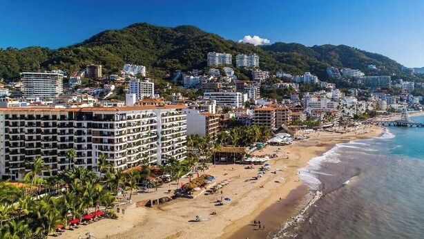 A coastal cityscape with a beach, hotels, and a mountainous backdrop. - Ocean View 2Br Condo-balcony-beach-pool VDS 111 (Puerto Vallarta)