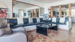 A living room with a sofa, a coffee table, and a mirror reflecting the room. - Ocean View 2Br Condo-balcony-beach-pool VDS 111 (Puerto Vallarta)