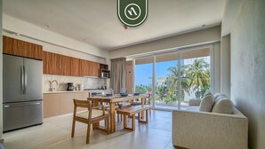 Una cucina moderna con zona pranzo, divano e un'ampia porta scorrevole in vetro che dà sull'esterno.