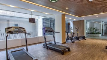 A modern gym with treadmills, stationary bikes, and a large mirror.