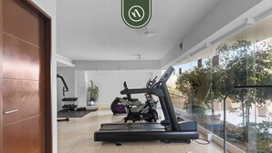 Une salle de sport moderne équipée d’un tapis de course, d’un vélo d’appartement et de poids.
