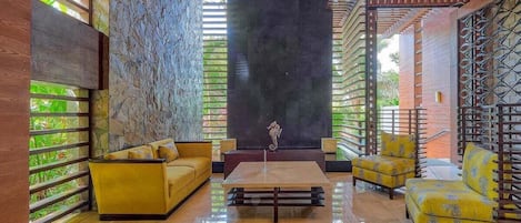 A lobby with a stone wall, a sofa, a coffee table, and a chair.