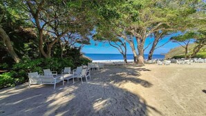 A beach with white lounge chairs arranged in rows, a sandy area, and a view of the ocean. - Amazing Condo - Beach Access - Spa - Pool (Punta de Mita)