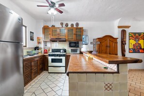 A kitchen with a refrigerator, stove, microwave, and wooden cabinets.