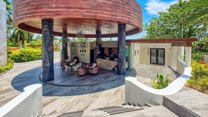 A circular outdoor seating area with a covered structure, a staircase leading to a building, and a small entrance building. - 2BR Condo in Bucerias - Pickleball Court - Gym (Bucerías)
