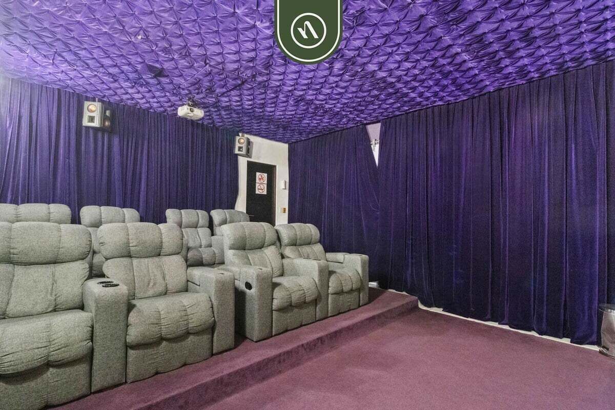 Un teatro con asientos cómodos y techo morado.