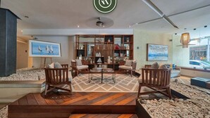A modern interior with a wooden floor, seating area, bookshelves, and artwork.