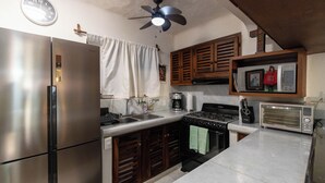 A kitchen with a stainless steel refrigerator, a stove, a microwave, and wooden cabinets. - Ocean View 2Br Condo-balcony-beach-pool - 212 (Puerto Vallarta)