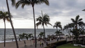 A beachside promenade with palm trees, a beach, and a restaurant area. - Ocean View 2Br Condo-balcony-beach-pool - 212 (Puerto Vallarta)