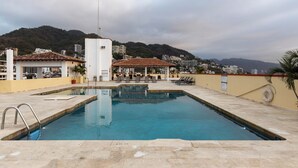 A swimming pool with a view of a city and hills in the background. - Ocean View 2Br Condo-balcony-beach-pool - 212 (Puerto Vallarta)