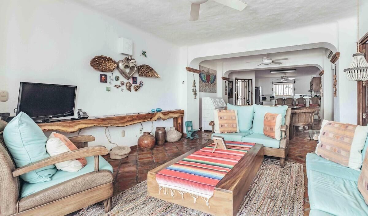 Un salon comprenant un téléviseur, un canapé, une table basse et des objets de décoration.